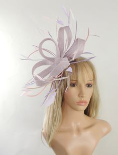 Hats By Cressida Kentucky Derby & Ascot Fascinator Hats Laveder Lilac and Baby Pink Regan Sinamay Fascinator Pretty lilac sinamay loops with lilac and pink coque and biot feathers Fascinator hat body measures about 7-8 Inches wide,longer with feathers Mounted with a matching headband. If you prefer a headband to match your hair, please make a note at check out what colour headband you want. Our Regan Feather Fascinator is ideal for special occasions like Kentucky Derby, Royal Ascot, weddings, church and fancy cocktail parties. With an elegant looped design and feather accents, it's the perfect finishing touch for any look. This fascinator is mounted with a comfortable headband so you can wear all day. We make each hat to order just for you, we would prefer if you did not order for choice. Whimsical Adjustable Fascinator For Spring, Elegant Purple Headpieces As Gift, Fitted Lavender Hats For Spring, Lavender Fitted Hat For Spring, Fitted Lavender Hat For Spring, Whimsical Purple Mini Hat For Party, Adjustable Lavender Headpiece For Wedding, Spring Formal Lavender Hat, Adjustable Purple Mini Hats For Gifts