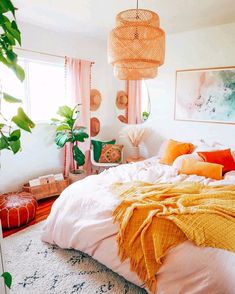 a bedroom decorated in shades of pink, orange and yellow with wicker lamps hanging from the ceiling