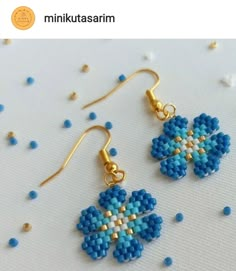 the beaded earrings are designed to look like an origami flower, and have gold - plated hooks