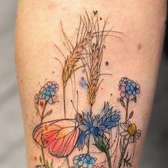 a tattoo with flowers and a butterfly on the side of a woman's leg