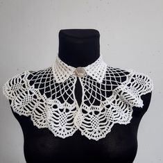 a white crocheted collar on a mannequin