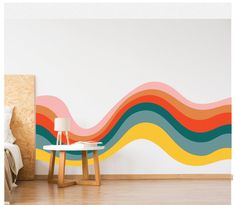 a room with a bed, table and wall mural