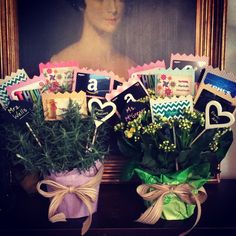 two vases filled with flowers sitting on top of a table next to a painting