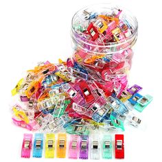 a container filled with lots of different colored plastic clips