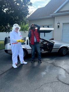 two people in costumes standing next to a car