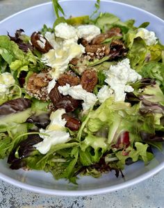 a salad with lettuce, feta cheese and raisins