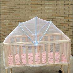 a baby crib with a clear cover on it's top and pink bedding