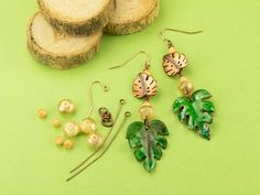 three different types of earrings sitting on top of a green table next to slices of bread