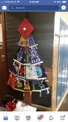 a christmas tree made out of t - shirts is displayed in an office cubicle