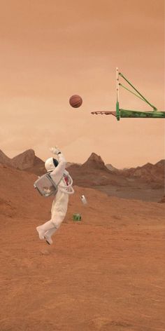 an astronaut is in the desert playing with a basketball