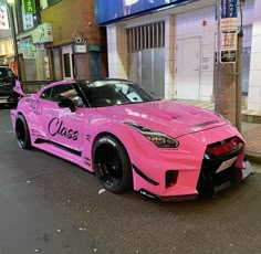 the pink sports car is parked on the side of the street