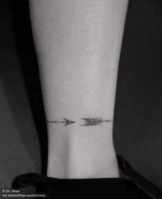 a woman's foot with an arrow tattoo on it