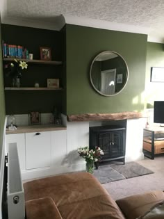 a living room with green walls and a fireplace