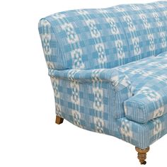 a blue and white checkered couch sitting on top of a wooden leg rester