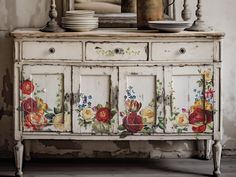 an old dresser with painted flowers on it