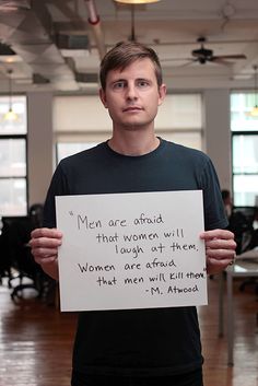 a man holding up a sign that says men are afraid that women will laugh at them