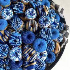 blue and gold decorated donuts in a bowl