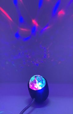 a blue and purple light shines brightly in the background as it sits on top of a table