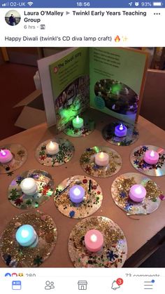 a table topped with lots of plates covered in candles and sparkles next to an open book