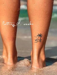 a person standing on the beach with their feet in the water and palm trees behind them