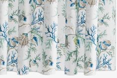 the curtains are decorated with blue and white flowers, leaves and birds on them as well as corals