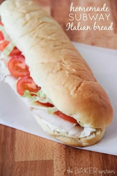 a sub sandwich with tomatoes and lettuce on it