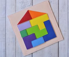 a colorful house made out of felt on top of a wooden table