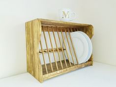 a wooden shelf with plates and cups in it