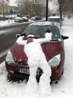 a car covered in snow on the side of a road with a person standing next to it