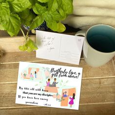 there is a postcard on the table next to a cup of coffee and plant