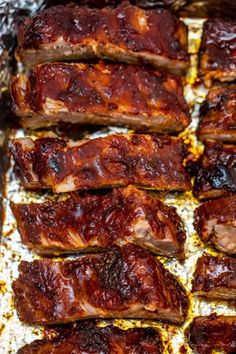 barbecue ribs are lined up on a baking sheet and ready to be cooked in the oven