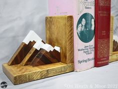 three wooden booksends are sitting next to each other in front of some books