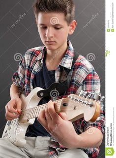 a young boy is playing an electric guitar