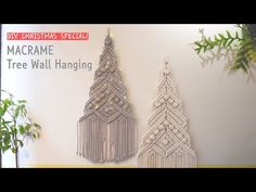 macrame tree wall hangings are displayed in front of a christmas card board