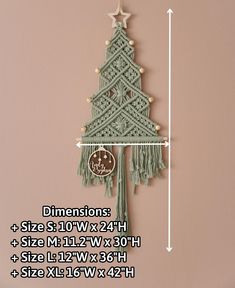 a crocheted christmas tree hanging on the wall next to a ruler with measurements