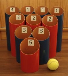 several cups with numbers and a tennis ball on the floor