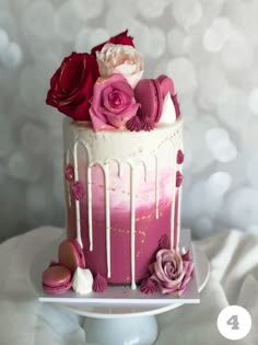 there is a pink and white cake with flowers on it