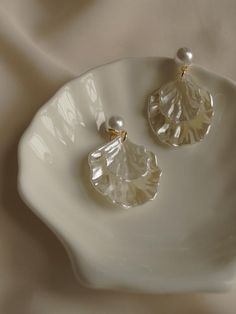 a pair of earrings on a white plate