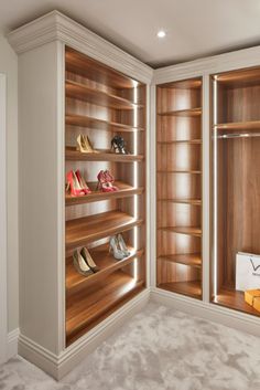 a walk in closet filled with lots of wooden shelves and shoes on top of them