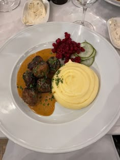 a white plate topped with meatballs and mashed potatoes