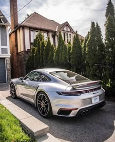 a silver porsche parked in front of a house