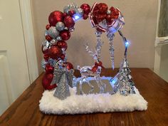 a christmas decoration made out of tinsel and ornaments on top of a wooden table