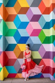 a woman standing in front of a colorful wall