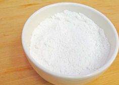 a bowl filled with white powder on top of a wooden table