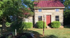 an old log house with a red roof