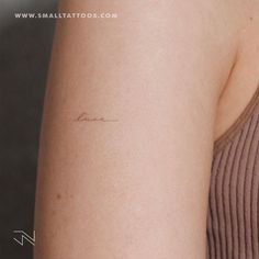 a woman's arm with a small tattoo that reads, love on the side