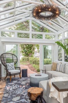 a living room filled with furniture and a large glass ceiling over the top of it