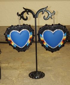 Heart shaped beaded earrings. super sparkly, super pretty  Made with a blue matte heart center,black, gold, and fire color seed beads. on short kidney hooks.  Perfect for VALENTINE'S DAY These detailed handmade beaded earrings are a stunning jewelry piece with their own unique style. Wear them anytime and anywhere!!  Each seed bead is physically woven with beading thread onto a stiffened felt stabilizer.Rhinestone cup chain banding is added, for extra texture and sparkle. Faux leather backing is glued and stitched on to the back of each earring then the edges are stitched with seed beads and bicones. Lots of time and patience goes into making each earring.  I appreciate you taking the time to look at my beadwork Thank you!! Heart Beaded Earrings, Beaded Heart Earrings, Fire Color, Handmade Beaded Earrings, Heart Center, Beaded Earrings Native, Beaded Heart, Beadwork Designs, Beading Thread