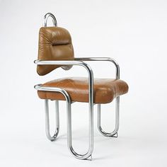 a brown leather chair sitting on top of a metal frame with an armrest and foot rest