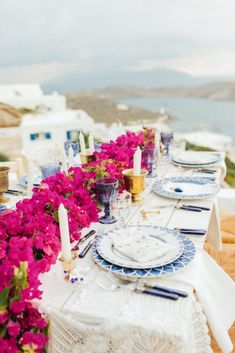 a long table with plates and flowers on it